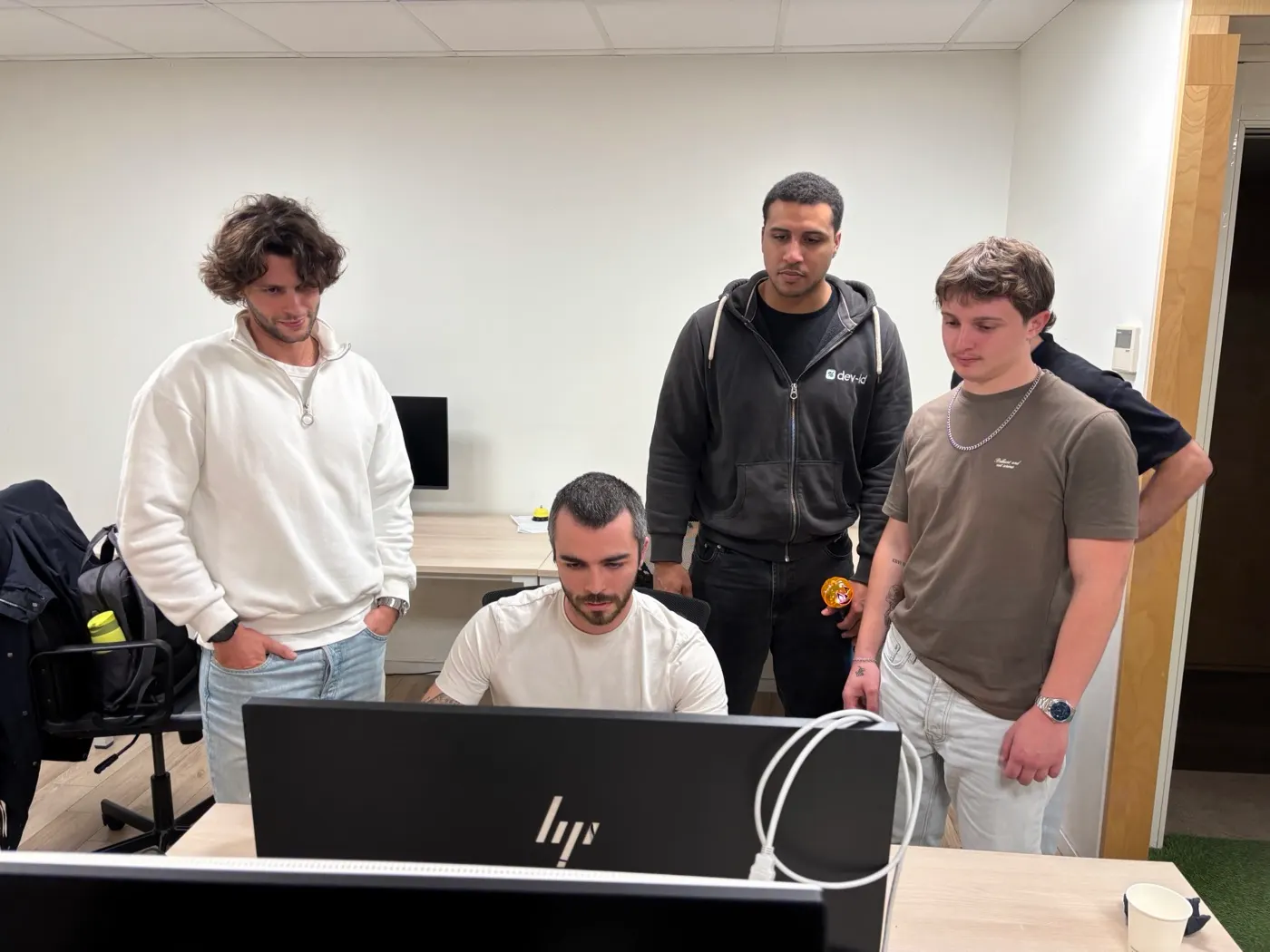 Four team members reviewing code together at a screen