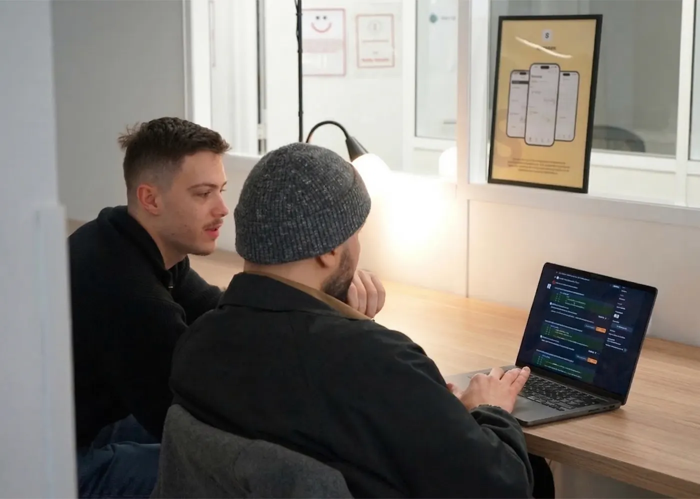 Two developers discussing code on a laptop at the Paris workshop